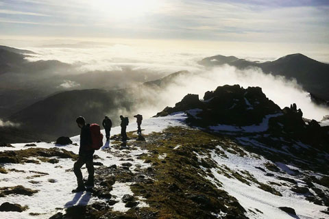 walkers on a snow flecked ridge